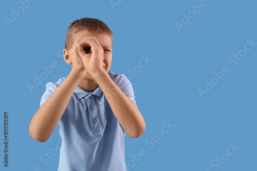 Quadro em tela Cute little boy with imaginary telescope on blue background
