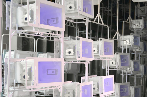 Conveyor system with microwave oven casings undergoing powder coating process in a workshop