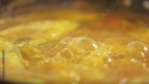 Extreme closeup shot of food cooking and curry boiling.