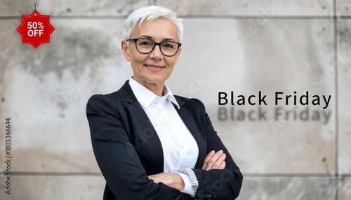 Black Friday Sale concept. Attractive middle aged woman with glasses wearing casual black jacket and white shirt standing isolated on wall background.