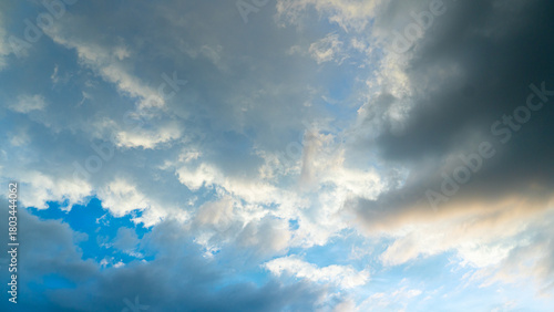 Dynamic Sky with Mixed Light and Dark Clouds. Wide angle shot captures a dramatic and turbulent sky filled with a mixture of clouds.
