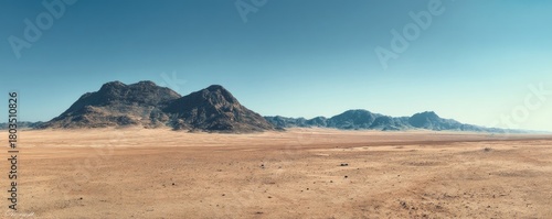 Wide desert plain with rugged rocky mountains under a clear blue sky, creating a vast warm landscape with open space for text, ideal for nature themes, travel concepts, or atmospheric design projects