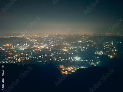 From afar, Dehradun glows like a quiet constellation, its city lights scattered across the valley as if stitched into the night.