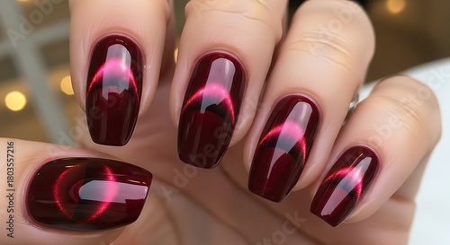 Opulent burgundy nails showcasing a lunar eclipse design with glossy finish