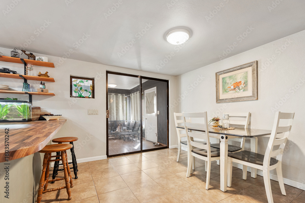 Fototapeta premium A dining room with a table, chairs, and a sliding glass door