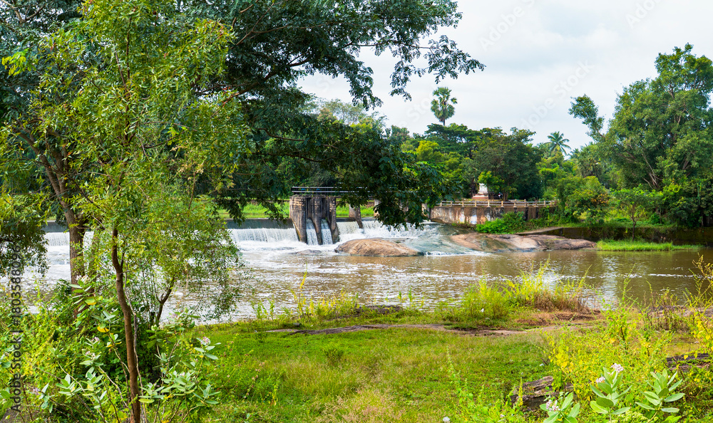 Obraz premium Scenic View of a check dam with Water Cascading over Rocks at Cheramangalam check dam in Palakkad, Kerala,
