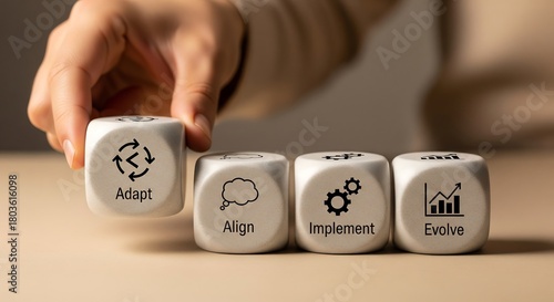 Hand arranging blocks with business strategy concepts: Adapt, Align, Implement, Evolve.