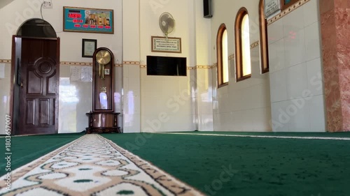 classic pendulum clock made of wood with a pendulum made of brass that swings left and right