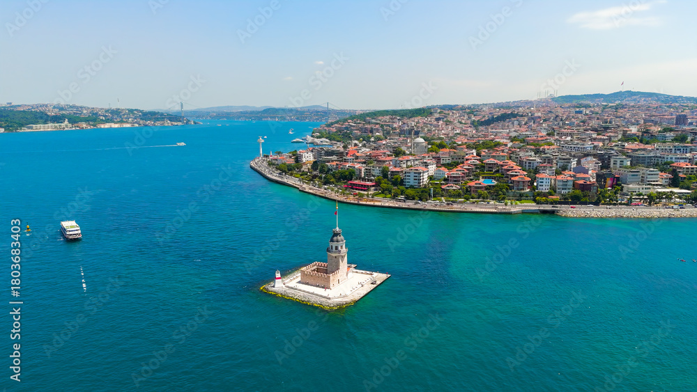 Fototapeta premium Istanbul, Turkey. Historic Maiden Tower Kiz Kulesi on rocky islet in Bosphorus with water taxis and small boats passing by on sunny day. Aerial View
