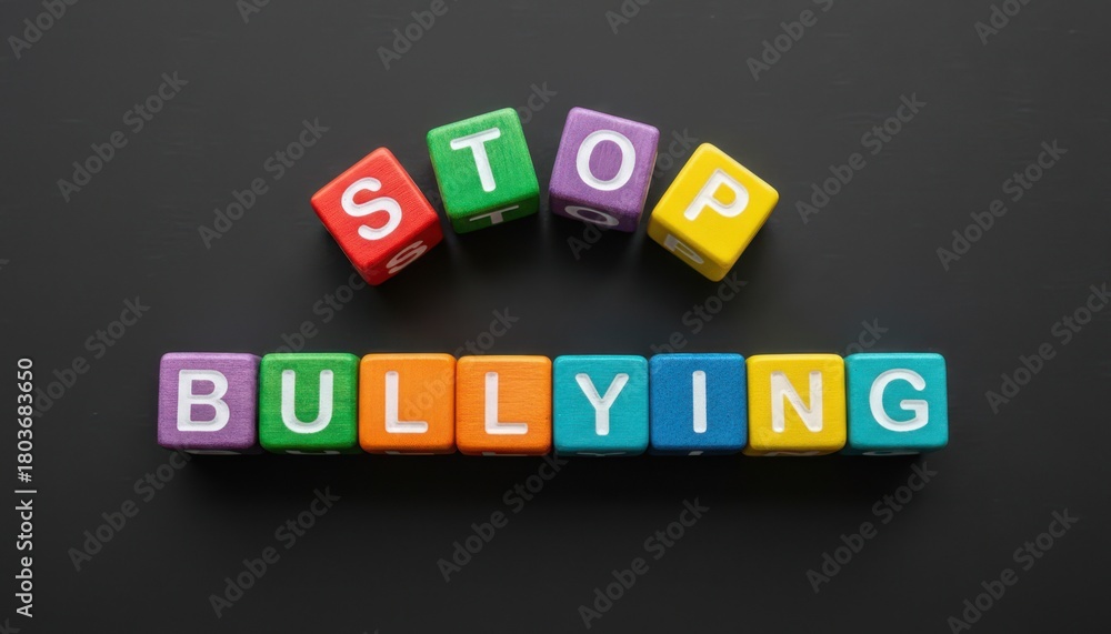 Obraz premium Colorful toy blocks arranged on a dark surface spelling stop bullying with bright letters creating a bold simple scene that delivers a clear message about awareness and safety