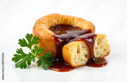 Fototapeta Naklejka Na Ścianę i Meble -  Close up shot presents tasty baked Yorkshire puddings with brown gravy and parsley decoration. British cuisine classic is on white plate. Delicious food concept for gastronomy blog.