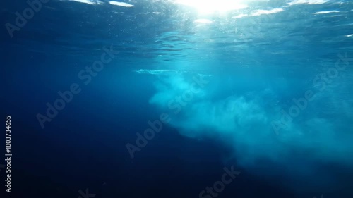 Wallpaper Mural Underwater shot of clear blue water with sunbeams and sand cloud in the ocean. Torontodigital.ca