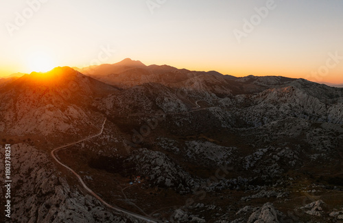 Majstorska road road at mountain Velebit in summer time in Croatia near croatia sea. Rocky peak of Tulove Grede at sunset