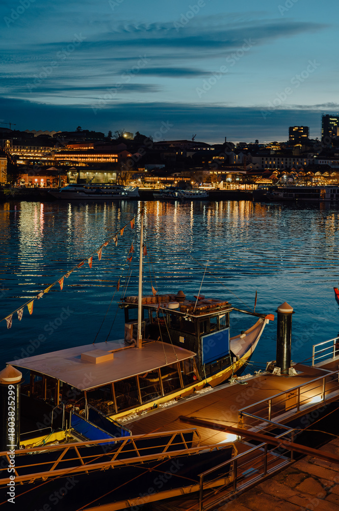 Fototapeta premium Traditional Rabelo boat docked on the Douro River at blue hour, Porto