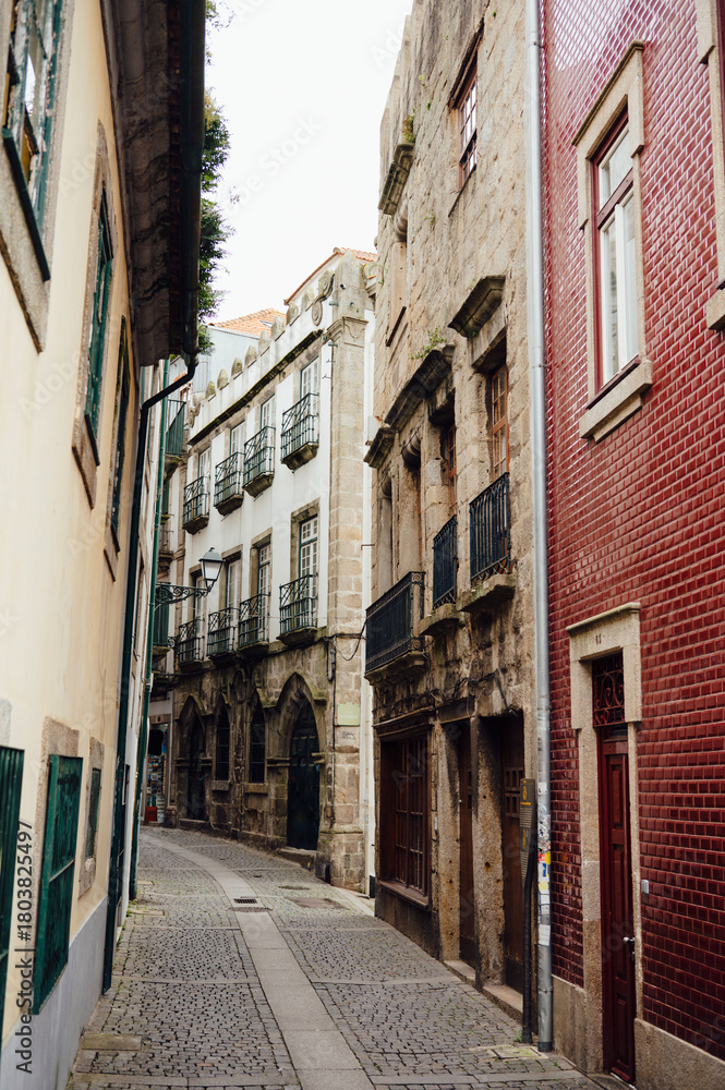 Naklejka premium Narrow Cobbled Street with Historic Buildings in Ribeira Porto