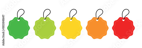 A row of colorful scalloped price tags with black string on a white background in a flat lay style
