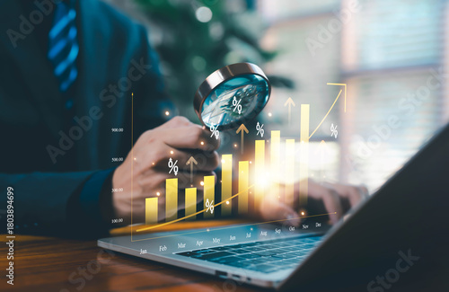 Fototapeta Naklejka Na Ścianę i Meble -  Business professional analyzing a rising financial chart with a magnifying glass, representing data analytics, market growth, investment performance, economic trends, and strategic decision-making