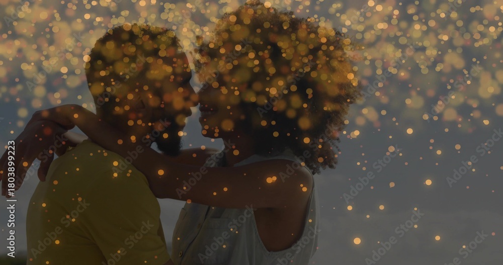 Naklejka premium Embracing couple holding close at beach at dusk, with yellow shirt sleeveless top and golden bokeh