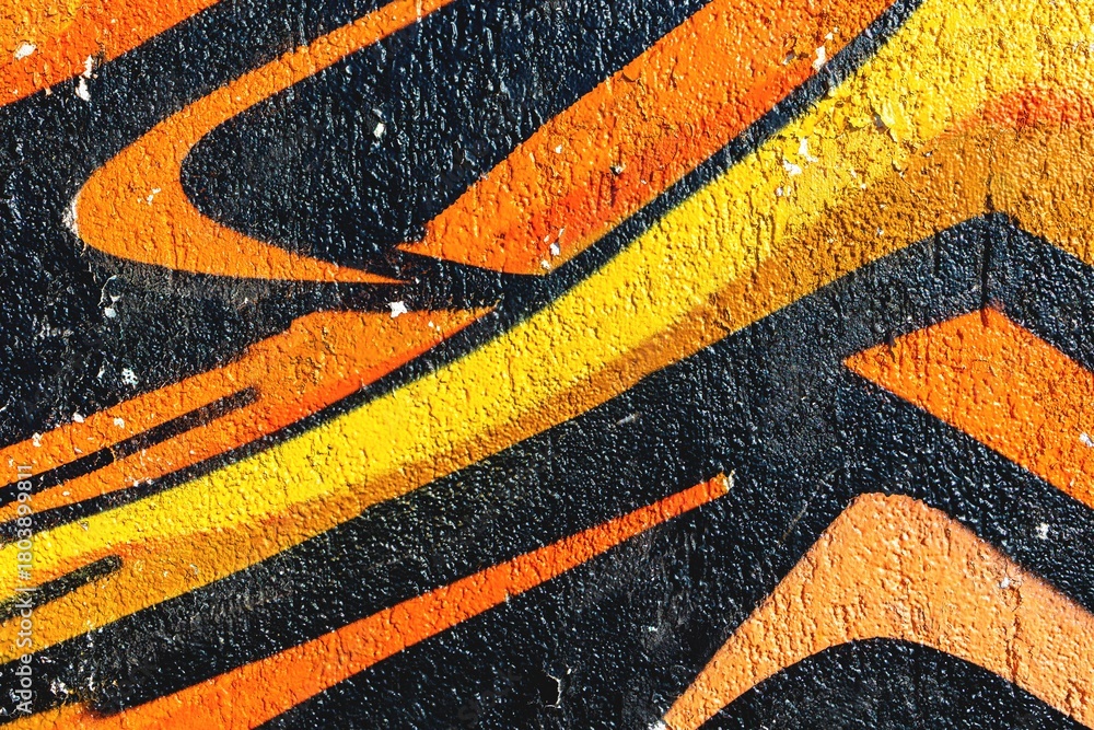 Naklejka premium Bold abstract graffiti pattern in orange, yellow, black. Urban 90s aesthetic, vibrant texture, dynamic street art. Posters, urban designs, creative backgrounds, gritty visuals.