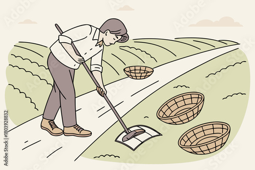 Man sweeping the path between fields with baskets nearby