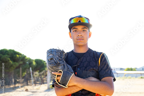 Young male baseball player posing confidently on field