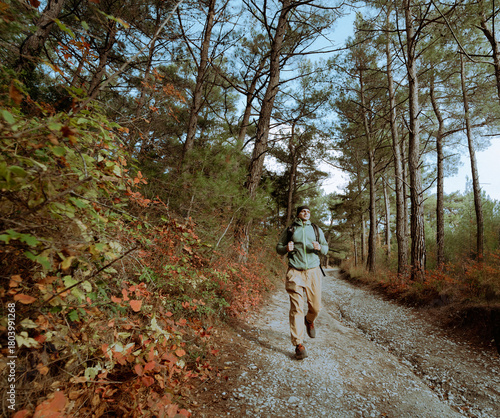Happy hiker man walk on the autumn path