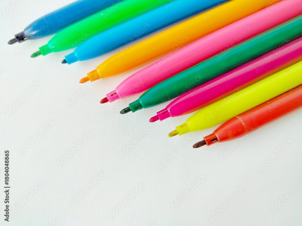 Fototapeta premium colorful uncapped markers on a white background