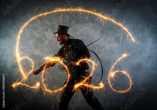 Schornsteinfeger in Arbeitskleidung schreibt mit Wunderkerzen, 2026. Symbolbild für das Neue Jahr.