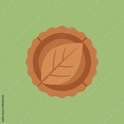 A stylized leaf inside a round pie crust on a green background.