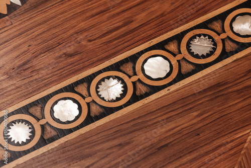 A close-up view of a parquet flooring wood inlay on a polished hardwood surface