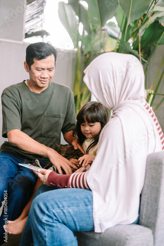 Happy Asian Family Bonding with Pet Cat at Home