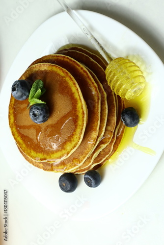 Tasty homemade pancakes with honey and berries