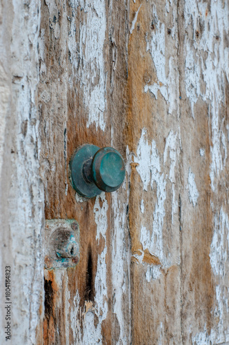 An old dilapidated door with a copper handle