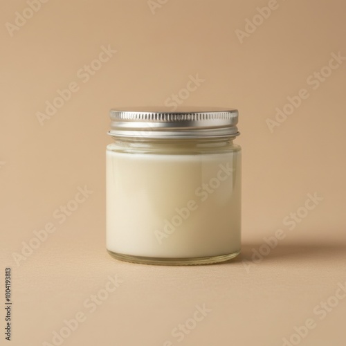 Homemade tallow balm in a clear jar. The rich, creamy texture of this natural moisturizer is highlighted by soft, studio lighting. Minimalist aesthetic.