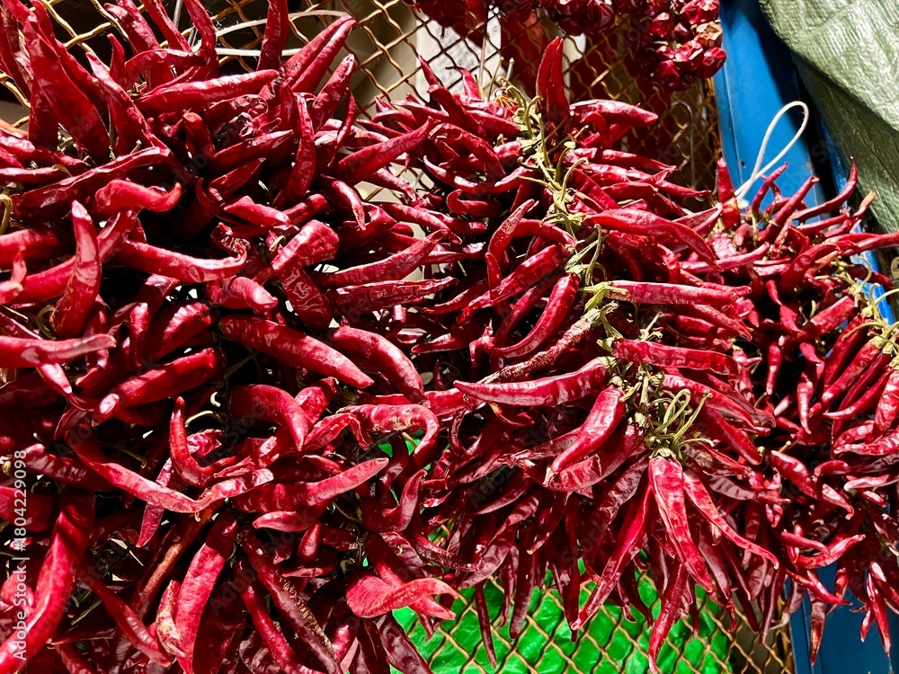 Fototapeta premium Dried red chili peppers hanging at market in budapest