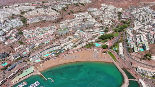 Puerto Rico de Gran Canaria, Canary Islands, Spain: Aerial view of tourist resort, Playa de Puerto Rico beach, summer day with clear blue sky - landscape panorama of Atlantic Ocean islands from above
