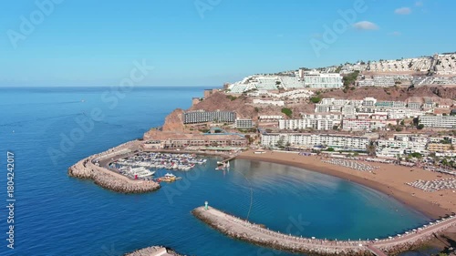 Puerto Rico de Gran Canaria, Canary Islands, Spain: Aerial view of tourist resort, Playa de Puerto Rico beach, summer day with clear blue sky - landscape panorama of Atlantic Ocean islands from above
