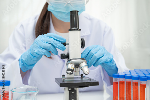Scientist medical professional use microscope for research in science laboratory.