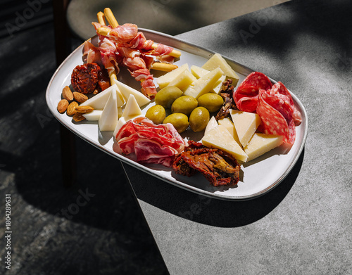 Delicious charcuterie board with meats, cheeses, and nuts in outdoor setting