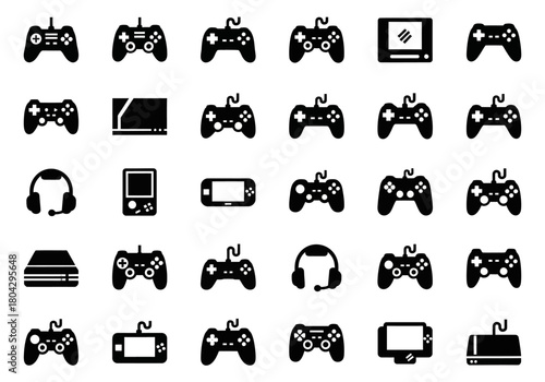 Solid glyph icon set of video game hardware, including various game controllers, consoles, handhelds, and headsets for digital entertainment