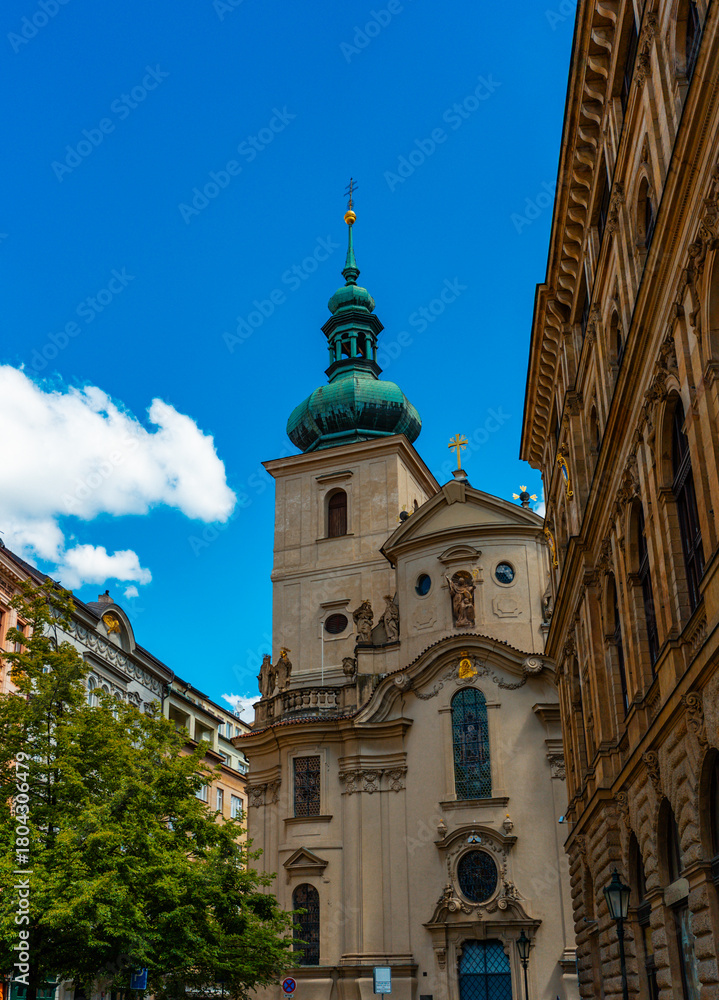 Fototapeta premium Ancient Saint Gall Church tower among Prague city buildings.