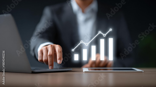 Focused businessman using technology for financial analysis and investment planning. glowing chart shows business growth, profit, and stock market success on digital tablet
