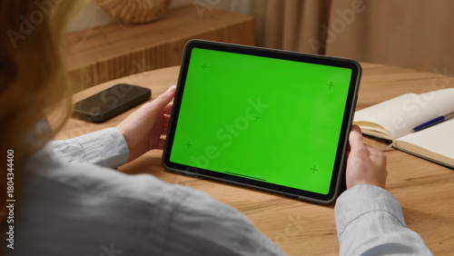 Woman sit desk use click digital tech tablet, green screen mock up. Hand swipe pad web site. Girl hold pad closeup press tap touch middle. Chroma key page. Cozy home background. Online app copy space