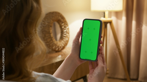 Woman use digital tech cell phone green screen mock up talk video call. Hand swipe click phone web site middle center. Girl hold mobile. Chroma key page. Cozy home background. Online app copy space.