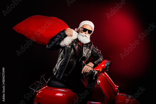 Cool Santa rocker on a red scooter with large bag wearing leather jacket and sunglass for festive season marketing