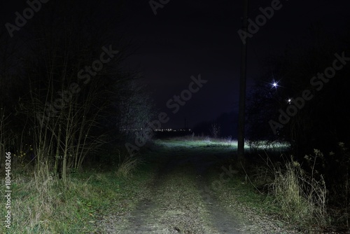 Night path leading to distant lights in the countryside