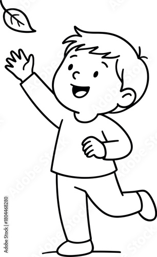 Joyful child reaching up to catch a falling autumn leaf