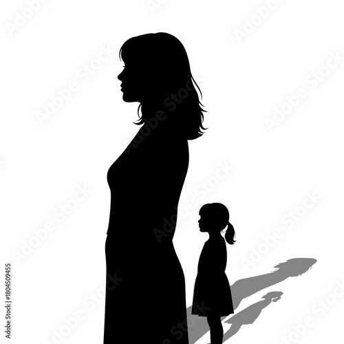 Silhouette of woman and child standing apart with long shadows and copy space