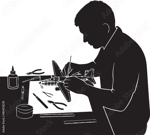 Silhouette of a man meticulously building a model airplane hobby at a workbench