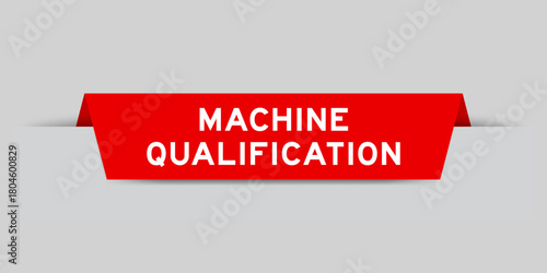 Red color inserted label with word machine qualification on gray background